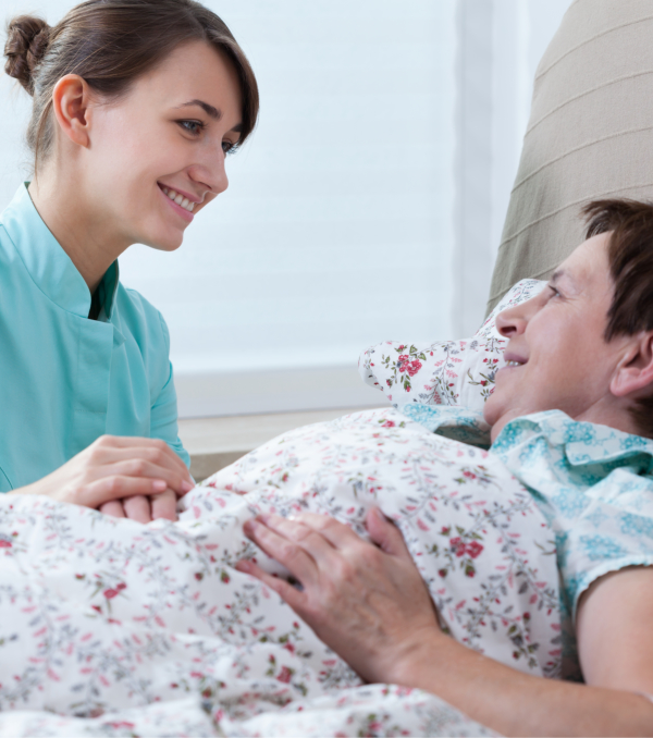 Nurse talking to a senior in bed
