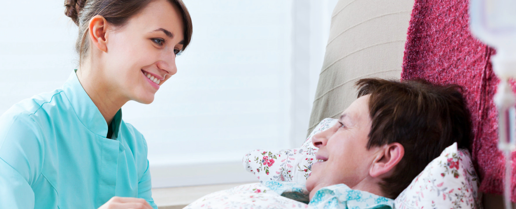 Nurse talking to a senior in bed